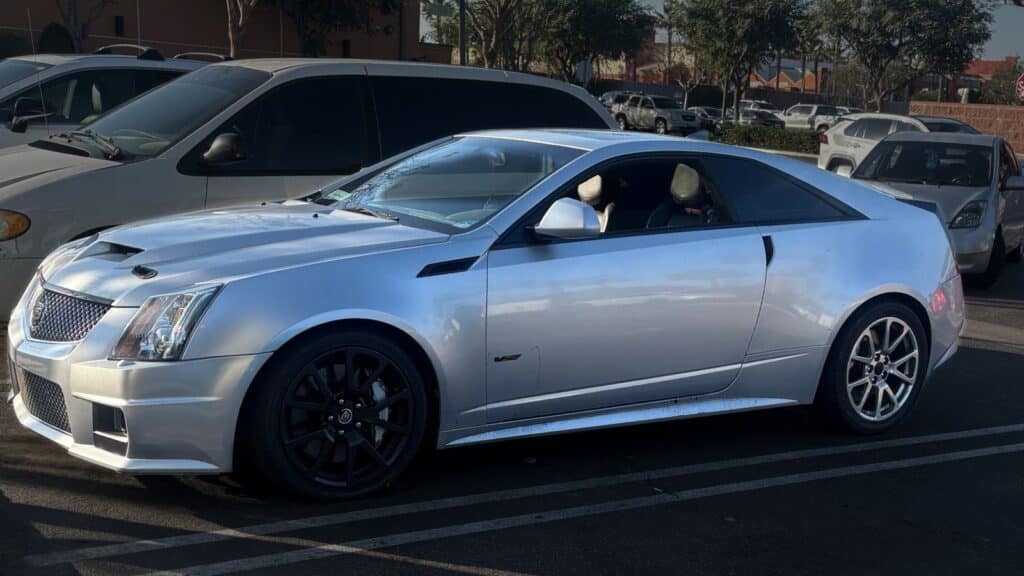 Stolen silver 2011 Cadillac CTS-V Coupe, VIN 1G6DV1EP1B0120393, License 9SAJ983. Features black rims, tinted tail lights, and body-matched spoiler. Stolen in Long Beach, CA.