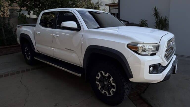 White 2017 Toyota Tacoma Off-Road 4x4 truck with black tonneau cover, tinted windows, and side steps.